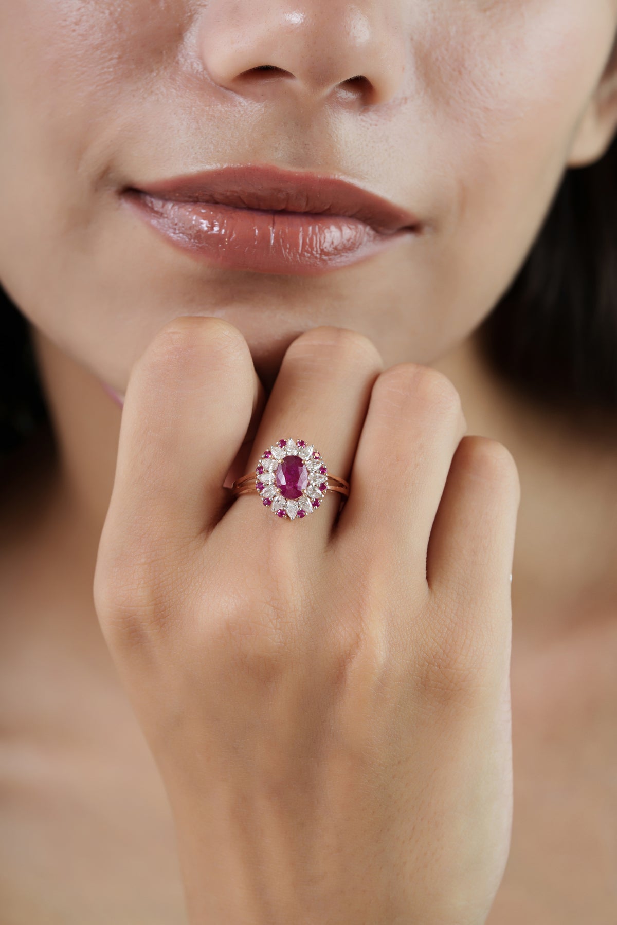 Vintage-inspired 14K gold oval ruby halo ring featuring marquise diamonds and round ruby accents in an elegant floral cluster design.
