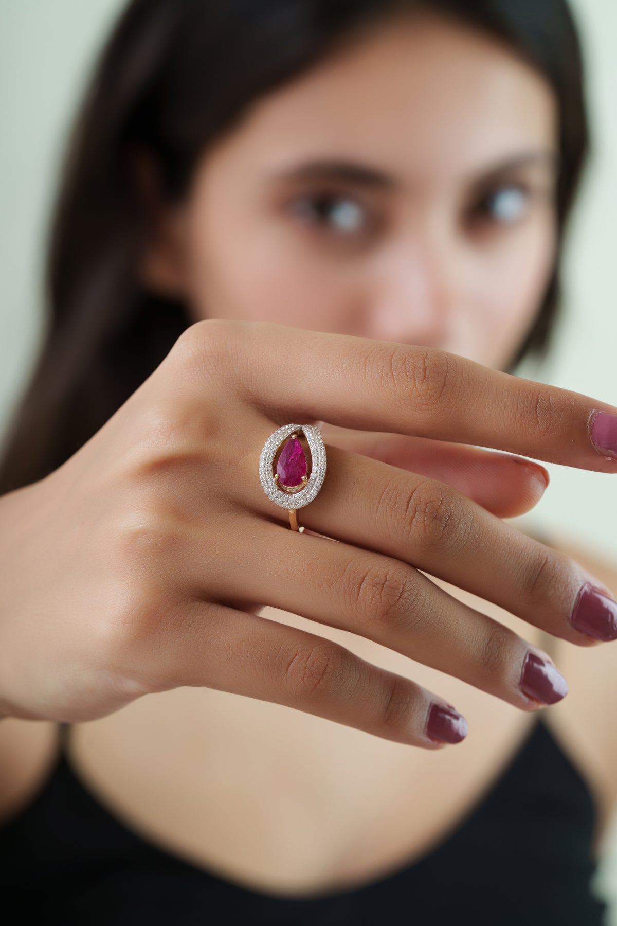 14K yellow gold ring featuring a natural pear-cut ruby surrounded by a sparkling double halo of round brilliant diamonds.