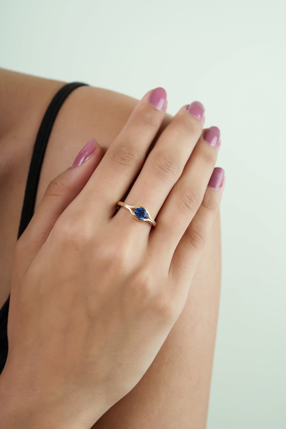 Oval blue sapphire gemstone ring with polished yellow gold-tone band