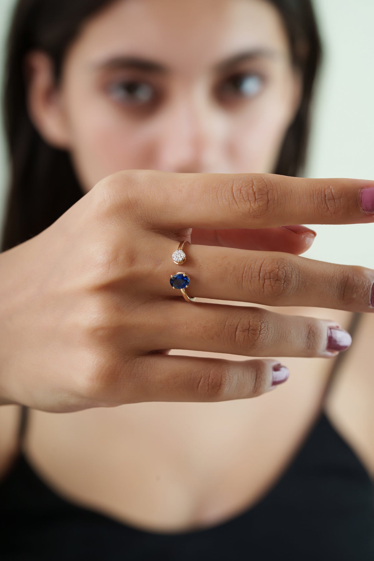 open bypass ring featuring a natural oval blue sapphire and round diamond cluster in a modern minimalist design.