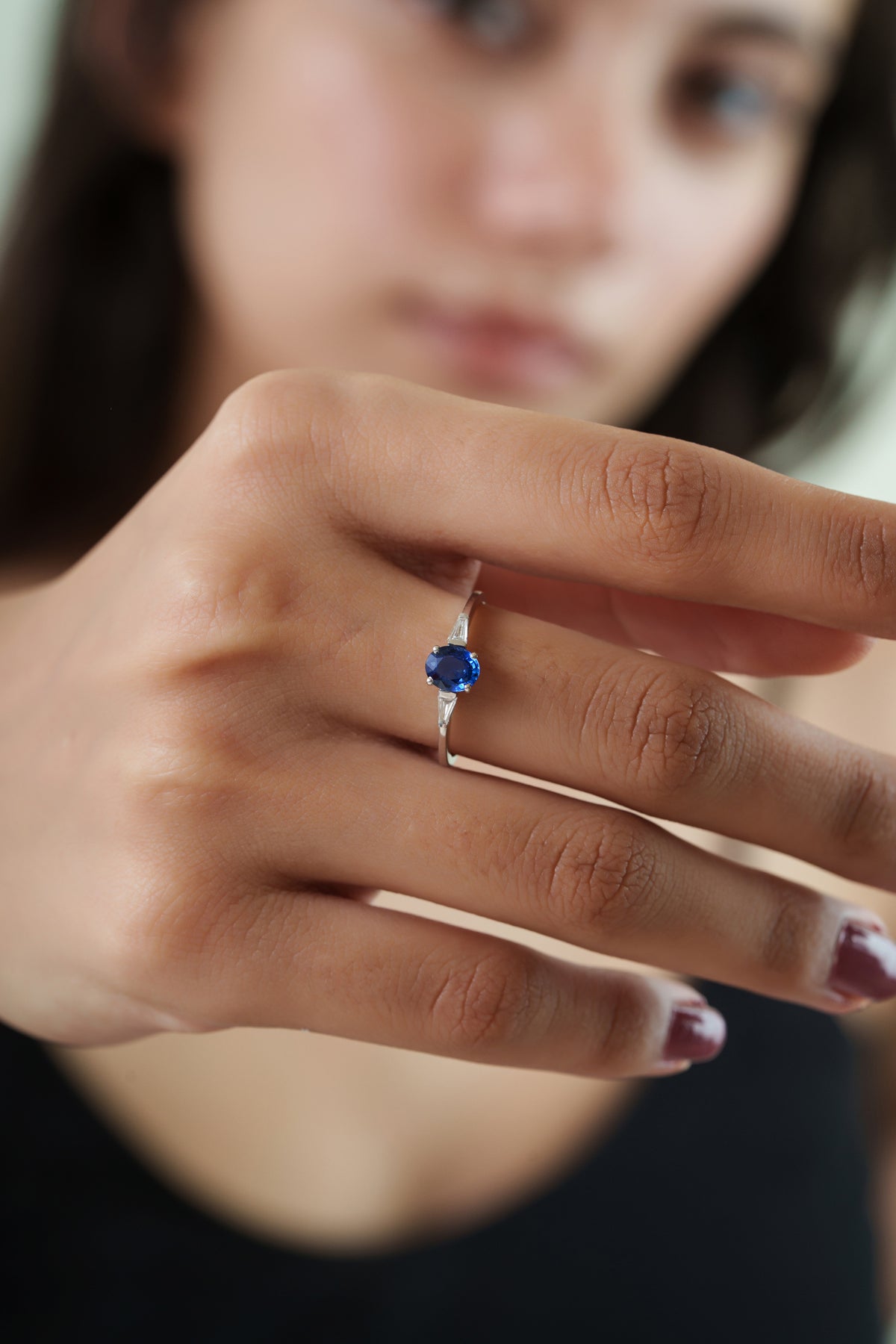 gold oval blue sapphire ring featuring tapered baguette diamond side stones in a minimalist solitaire engagement ring design.