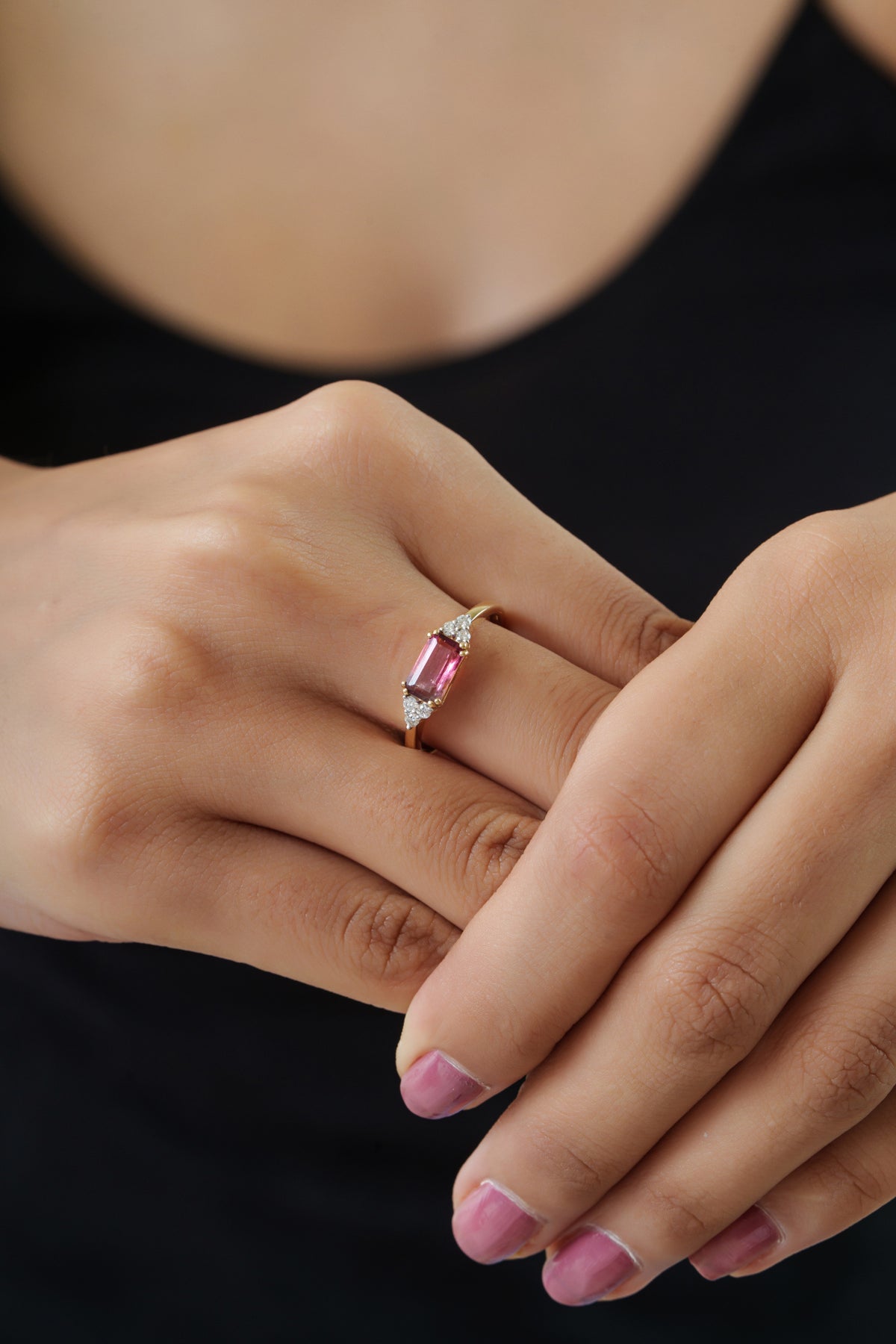 Elegant 14K gold ring featuring a natural emerald-cut pink tourmaline with sparkling round diamond side accents on a polished slim gold band, handcrafted as a timeless engagement or anniversary ring for women.