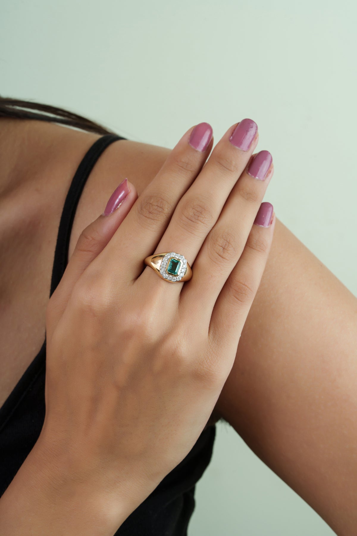 Elegant 14K yellow gold signet ring featuring a natural emerald-cut emerald surrounded by a sparkling round diamond halo, handcrafted as a luxurious vintage-inspired statement ring for women.