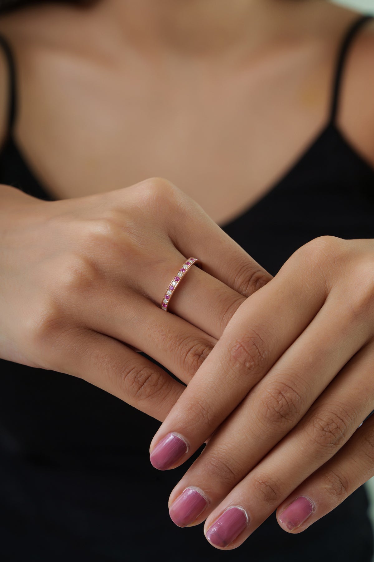 Elegant 14K rose gold curved wedding band featuring alternating natural pink sapphires and brilliant round diamonds in a slim stackable design perfect for weddings and anniversaries.